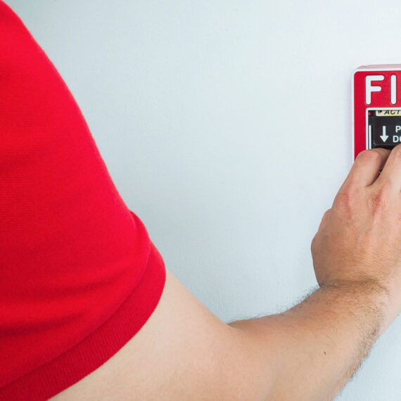 man-is-reaching-his-hand-push-fire-alarm-hand-station-(1)